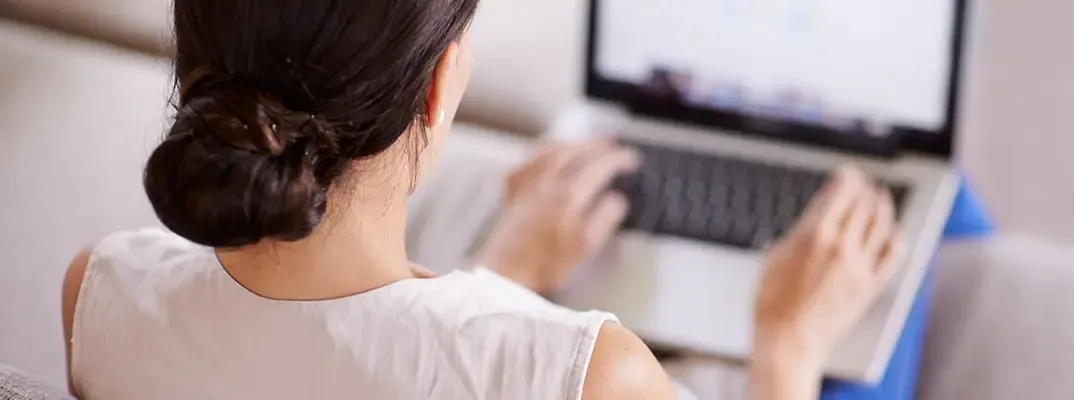 A woman typing on a laptop