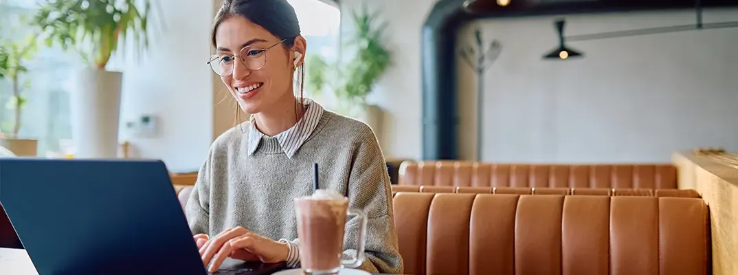 A woman working on a laptop in a diner.