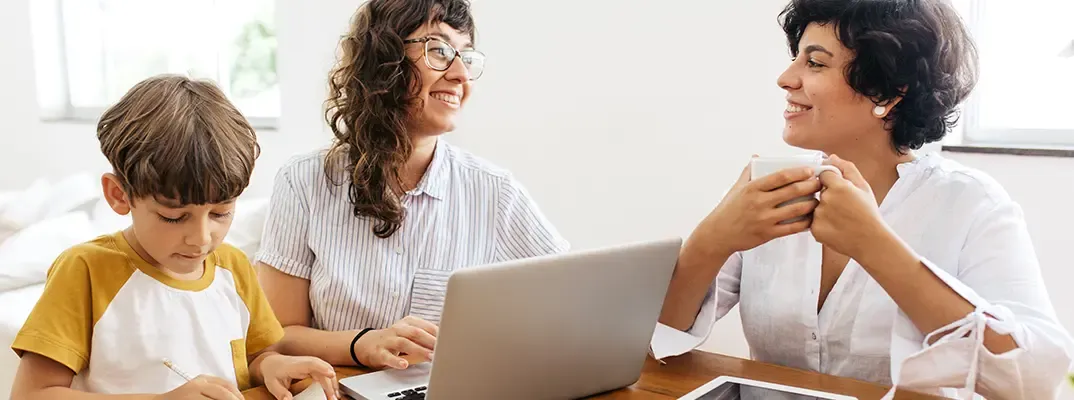 Two women paying bills online.