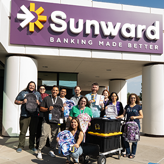 Sunward employees holding donated school supplies