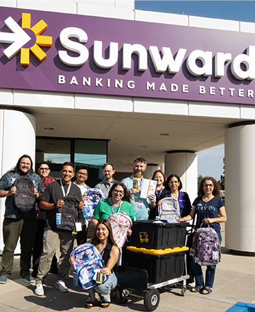 Sunward employees holding donated school supplies
