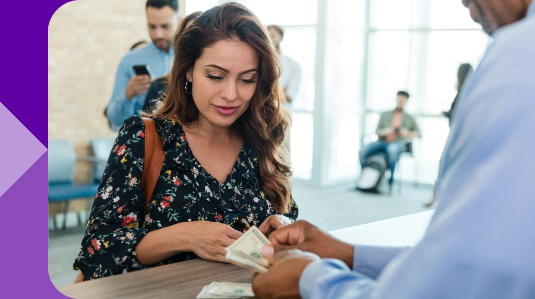 A woman getting cash from a teller.