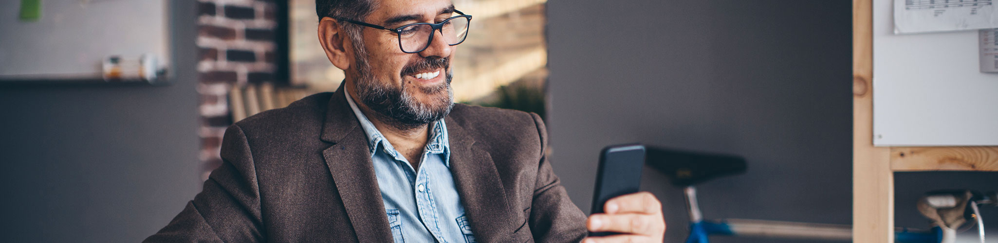Man in a suit looking at a smart phone