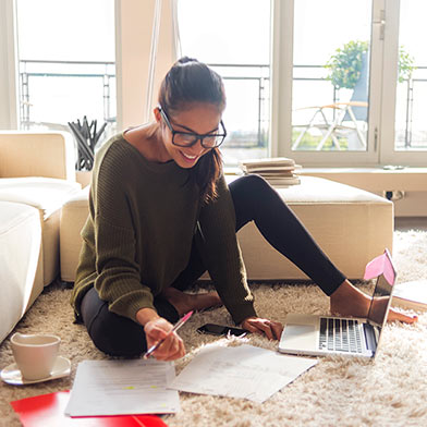 Teen sitting on floor with her laptop and some papers