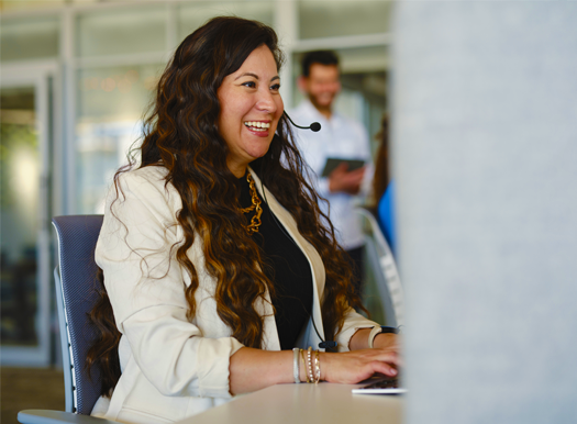 A woman with a headset working at a desk